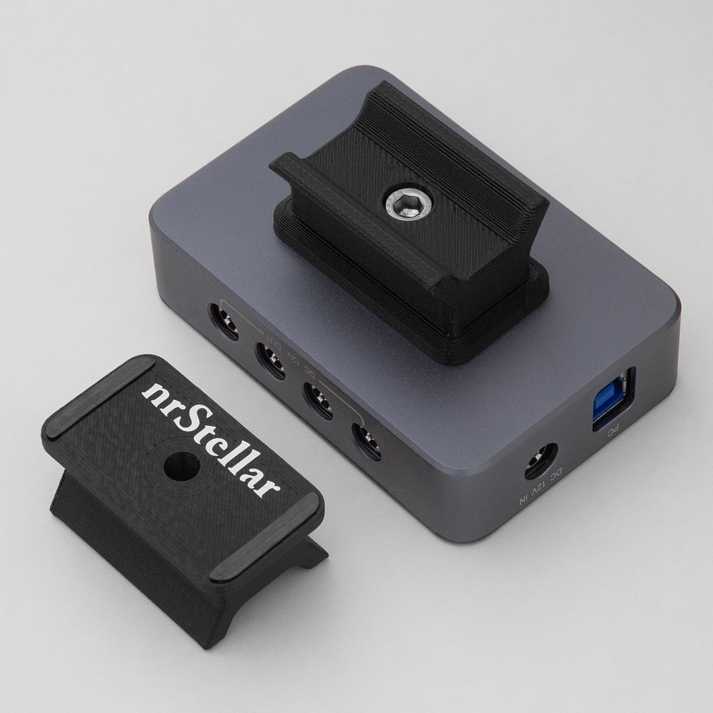 An nrStellar SV241 finderscope dovetail installed on an SVBONY powerbox. Next to it is another nrStellar SV241 finderscope dovetail, upside down to display the rubber padding and brand name.