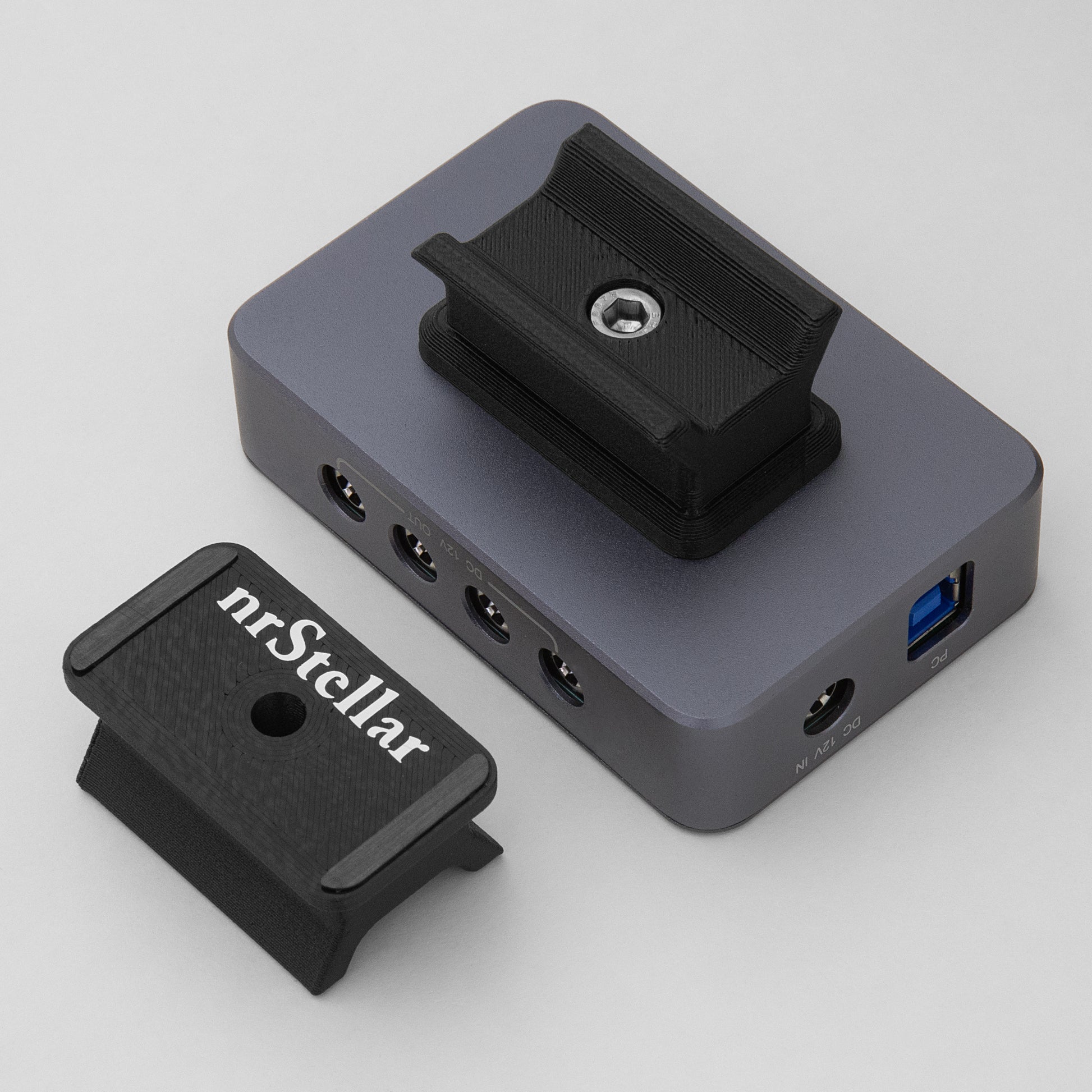 An nrStellar SV241 finderscope dovetail installed on an SVBONY powerbox. Next to it is another nrStellar SV241 finderscope dovetail, upside down to display the rubber padding and brand name.